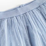 Detaljebillede af blå tylnederdel med prikmønster og elastik i taljen