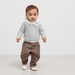 Lille børn iført grå trøje og brune bukser