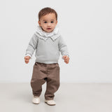 Lille børn iført grå trøje og brune bukser