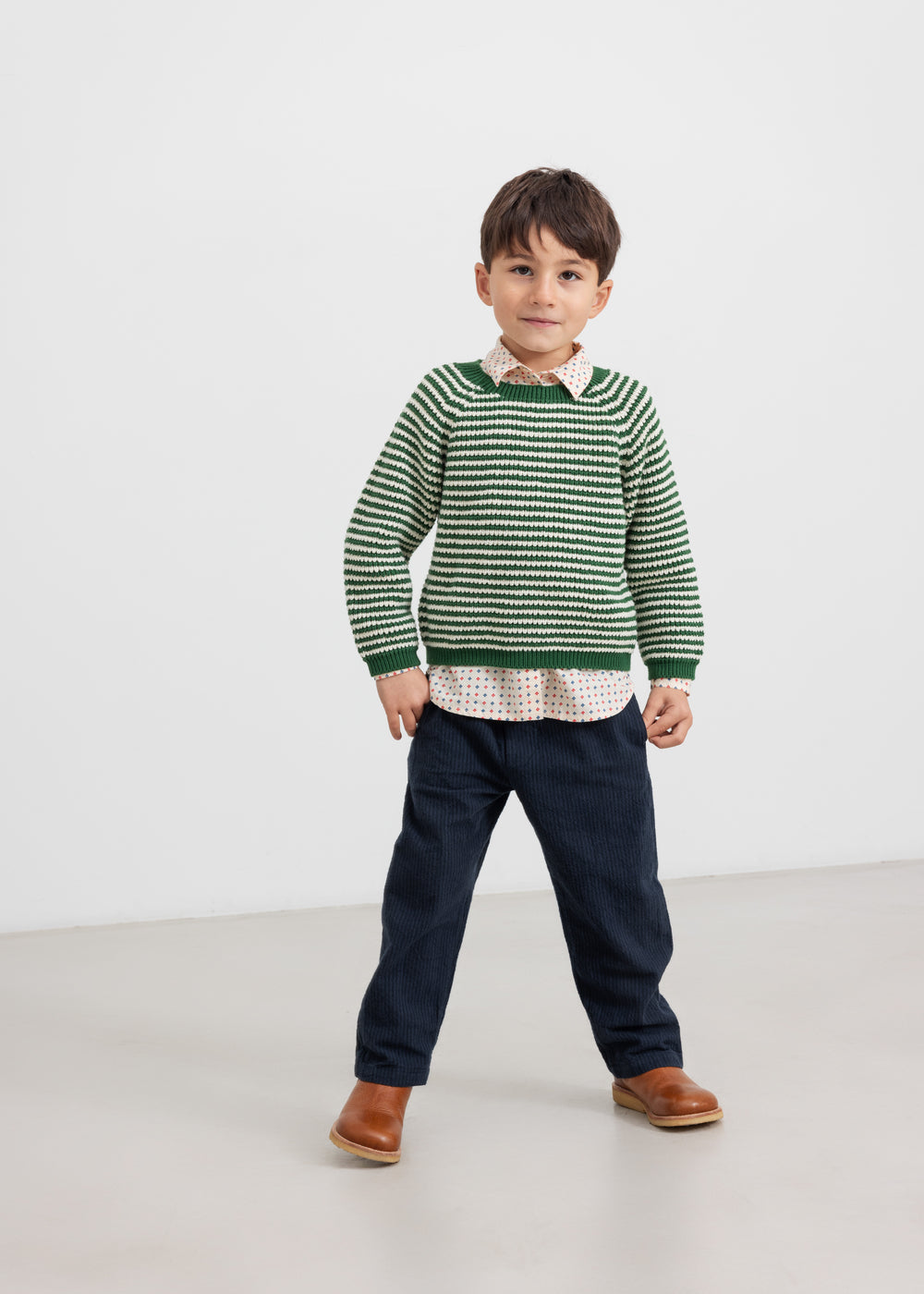 Børn iført mørkeblå bukser og grøn striktrøje