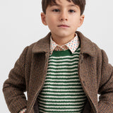 Dreng iført grøn stribet striktrøje med brun jakke