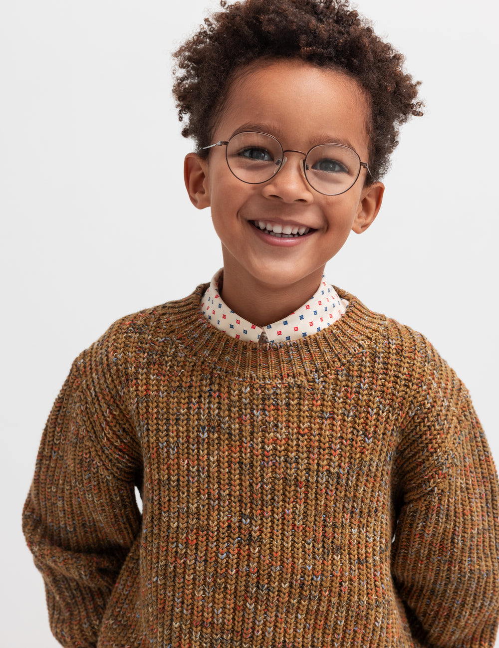 Glad dreng iført brunmeleret striktrøje