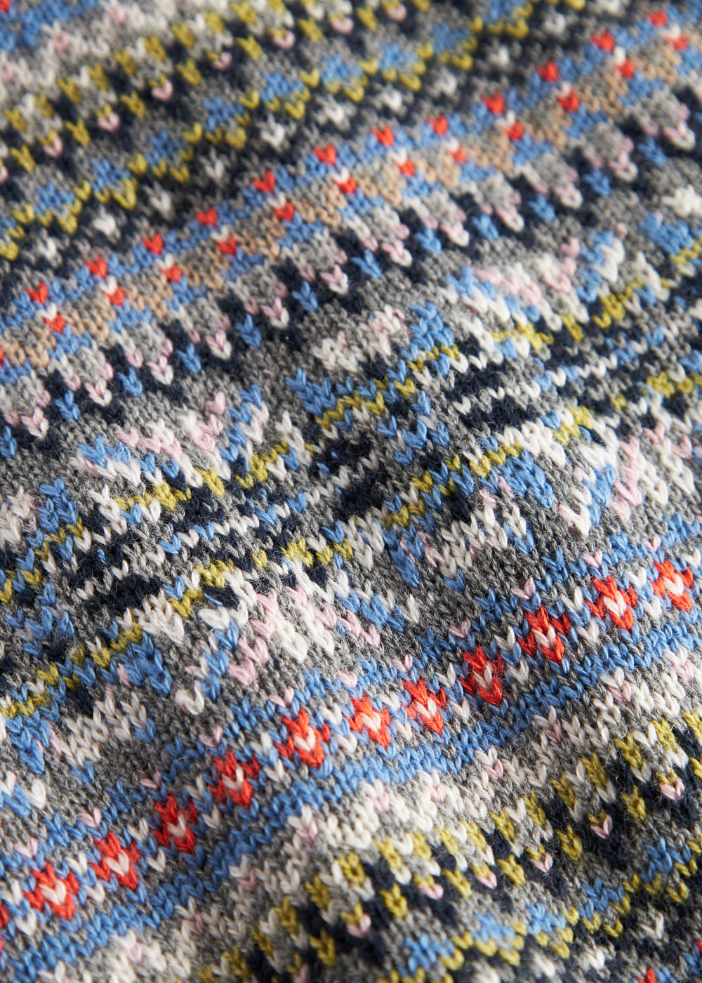 Strikket babyvest med farverigt mønster og V-hals