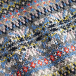 Strikket babyvest med farverigt mønster og V-hals