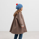 Pige bagfra med blå beret med rød kvast og brun frakke