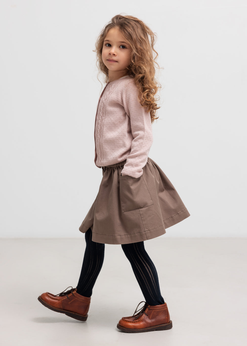 Børn iført kaki nederdel set fra siden