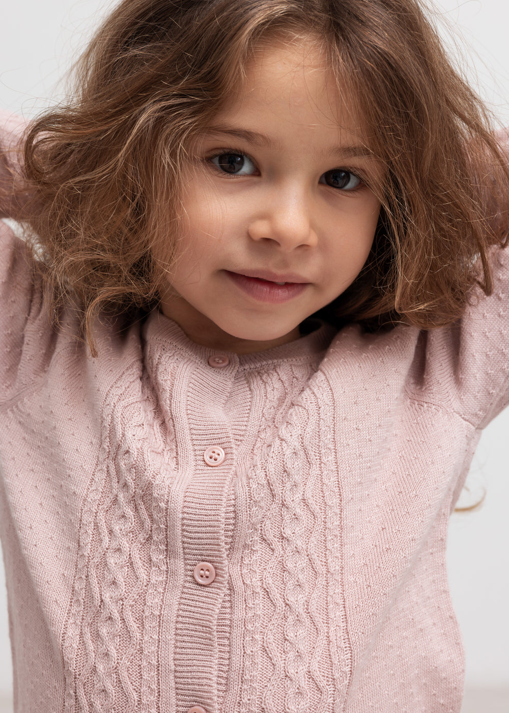 Børn med lyserød strikcardigan og krave, nærbillede
