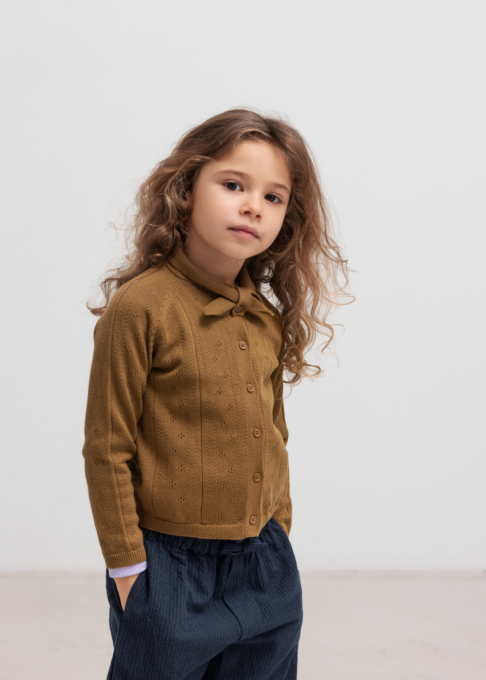 Børn iført brun strikket cardigan og mørkeblå bukser