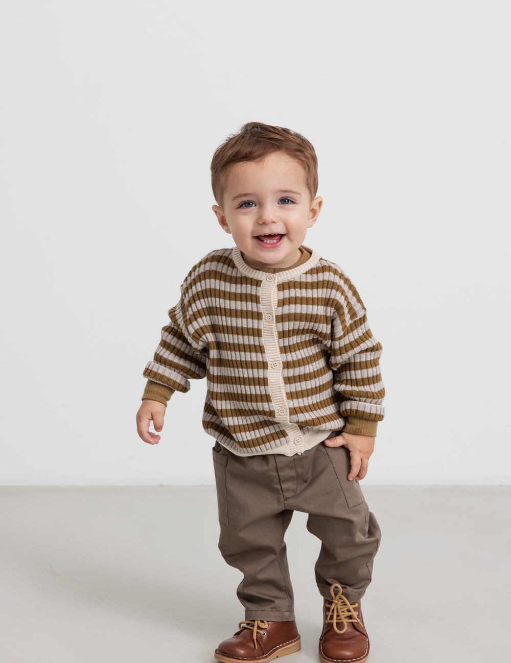 Børn iført stribet strikcardigan med knapper og brune bukser