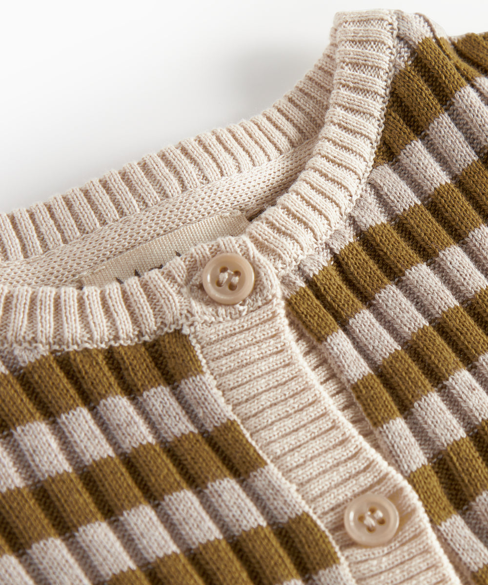 Detalje af knapper og ribkant på strikcardigan til børn