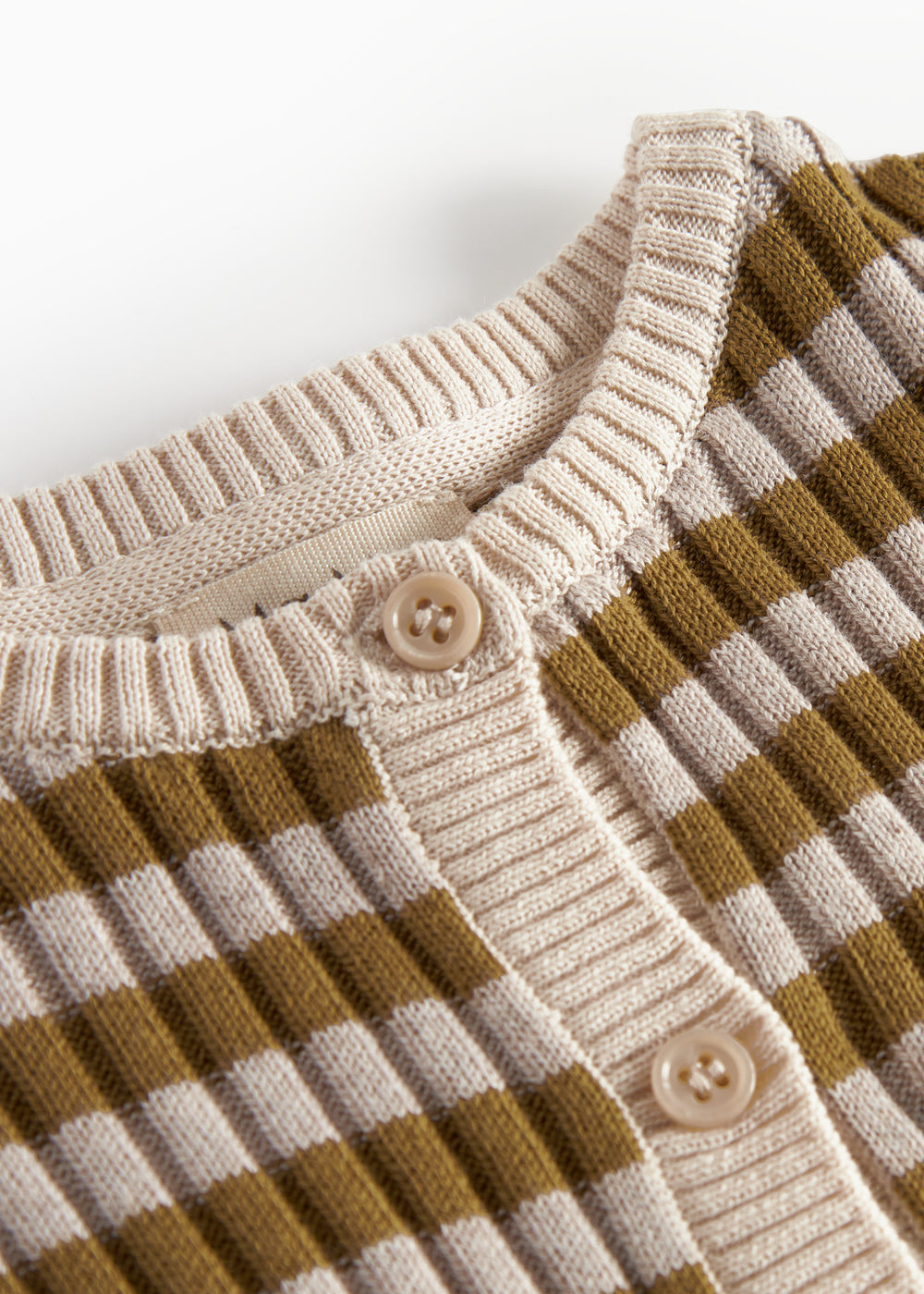 Detalje af knapper og ribkant på strikcardigan til børn