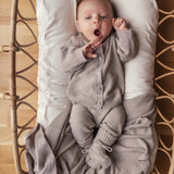 Baby iført beige strik babytøj