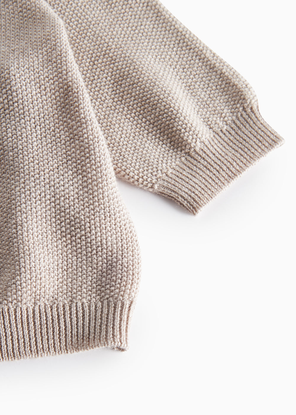 Nærbillede af ribkant ved ærme på beige/grå strikket babycardigan
