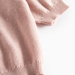 Nærbillede af ribkant ved ærme på lyserød strikket babycardigan