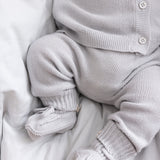 Nærbillede af ben i lys grå strikkede babybukser med ribkanter