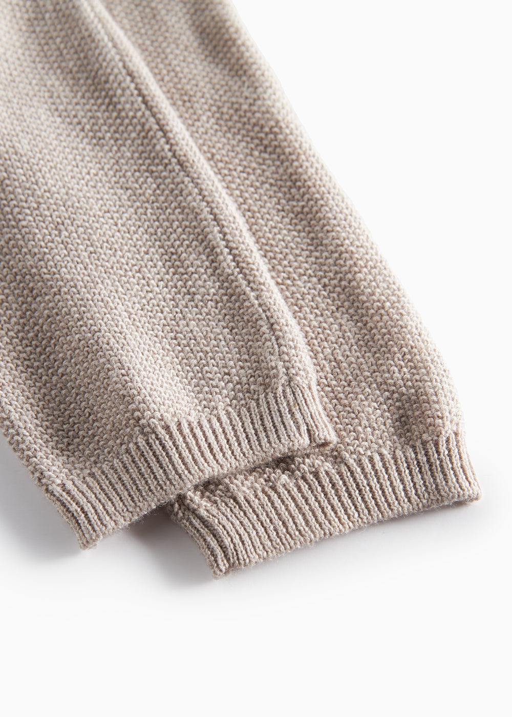 Nærbillede af beige strikket babybukser