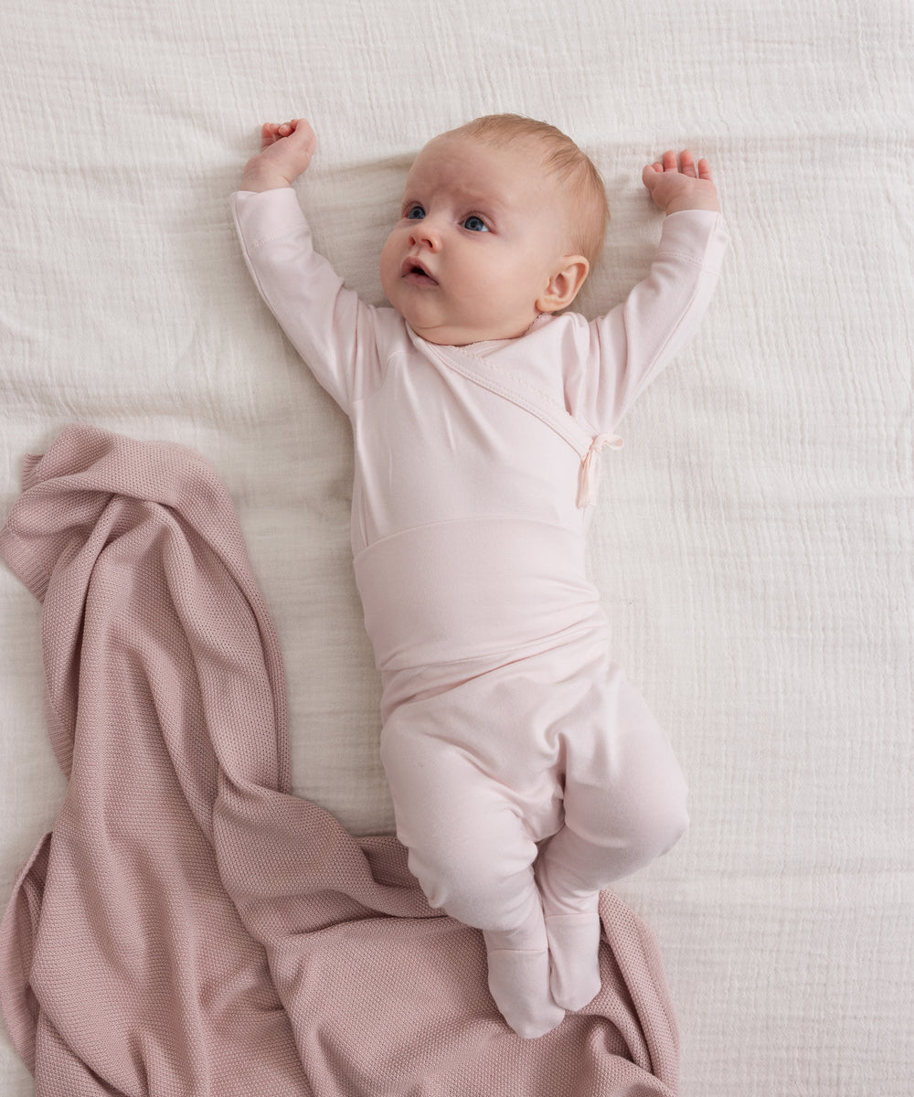 Baby med Lyserød strikket babytæppe