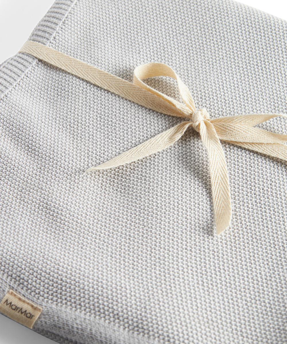 Grå strikket babytæppe