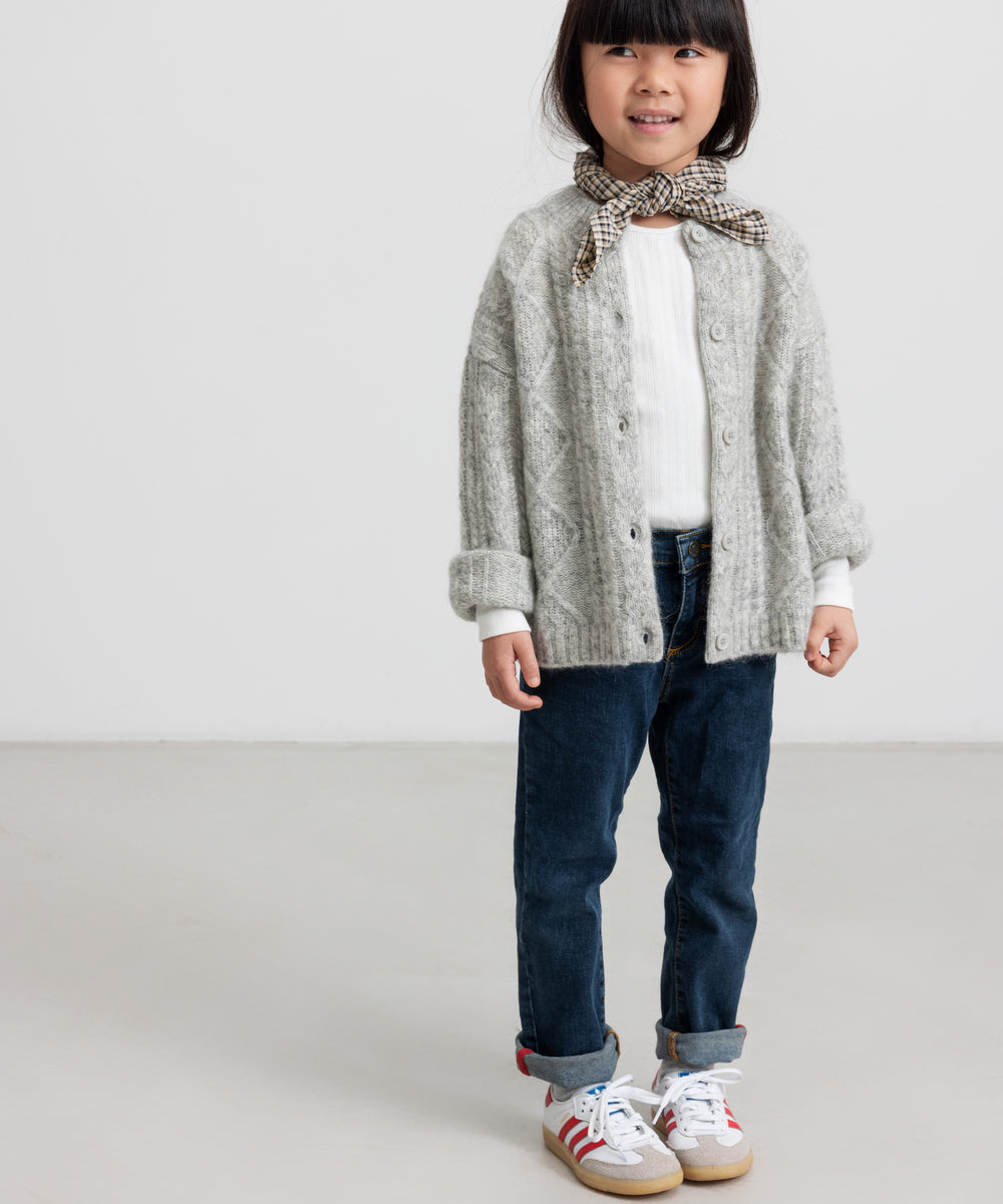 Børn iført lysegrå cardigan og jeans