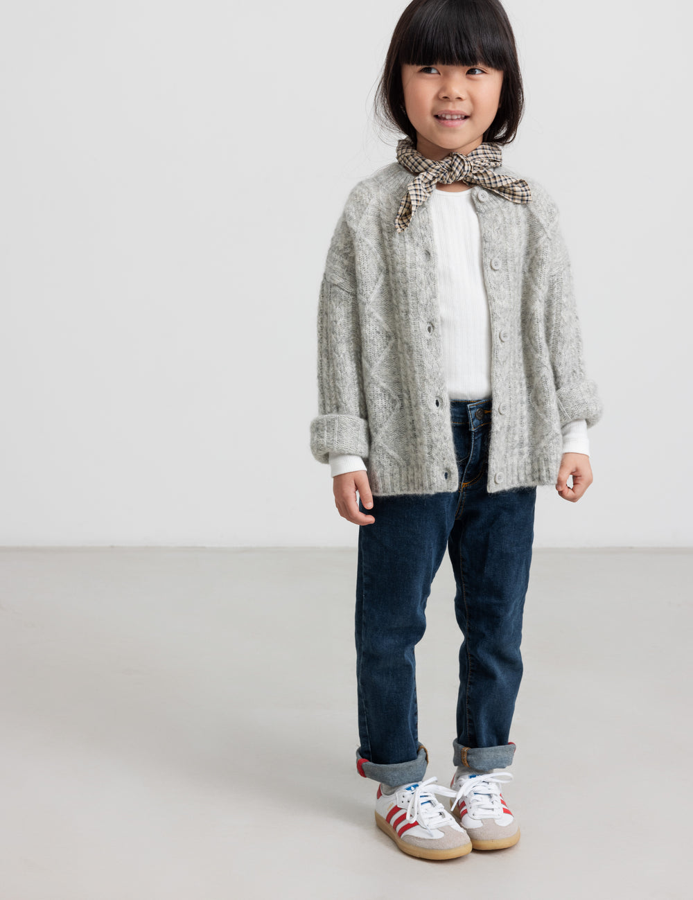 Børn iført lysegrå cardigan og jeans