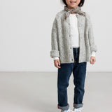 Børn iført lysegrå cardigan og jeans