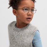 Dreng iført blå og hvid stribet bluse under grå strikvest