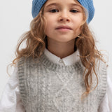 Børn iført grå strikvest over hvid skjorte og blå hue