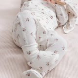 Baby iført blødt babytøj og futter liggende på ryggen