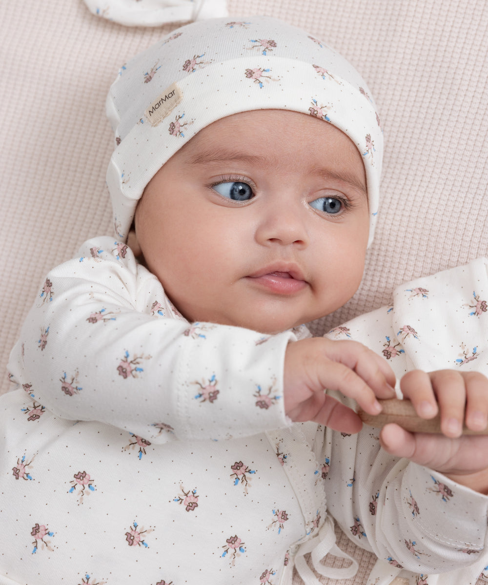 Baby iført mønstret hue og blød dragt