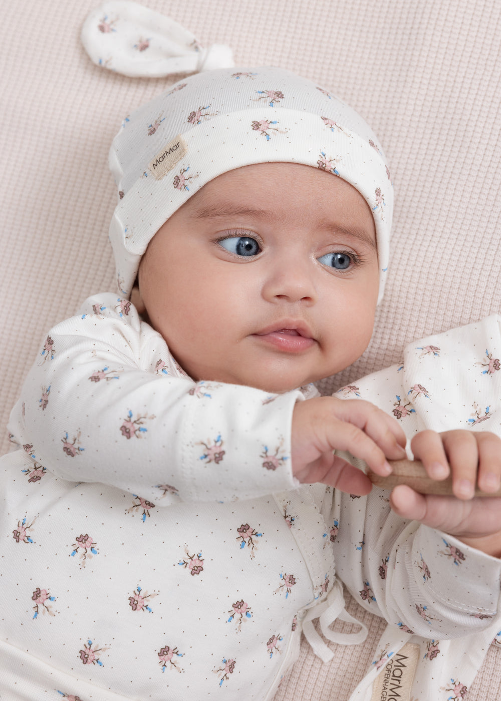 Baby iført mønstret hue og blød dragt