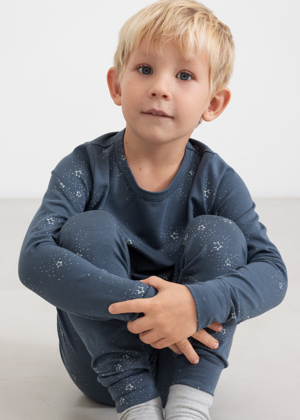 Dreng iført mørkeblåt pyjamasæt med stjerneprint