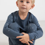 Dreng iført mørkeblåt pyjamasæt med stjerneprint