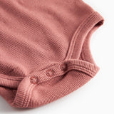 Støvet rosa ribstrikket body med lange ærmer til baby