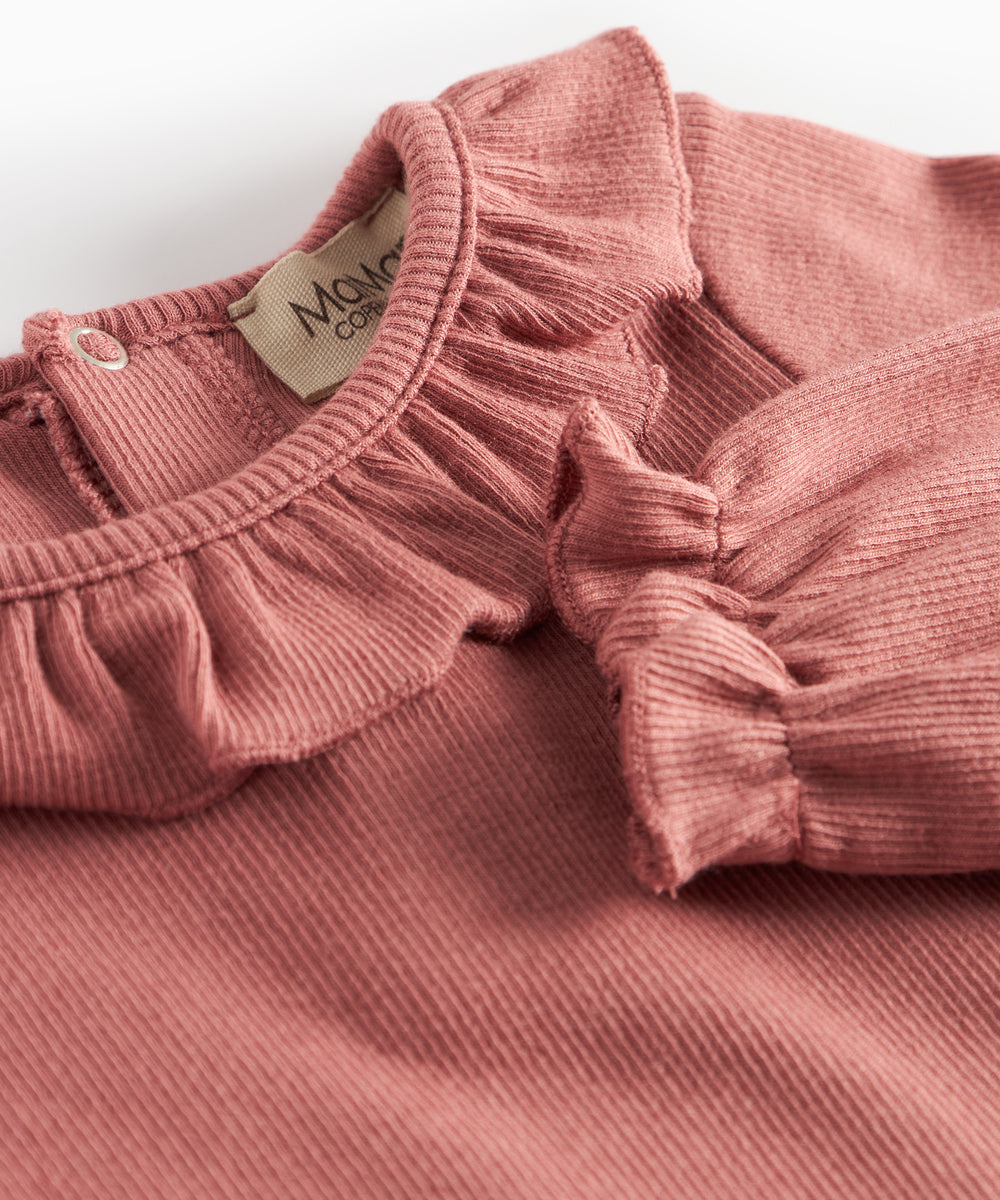 Støvet rosa ribstrikket babybody med flæsekrave og lange ærmer