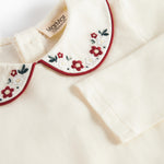 Hvid bodystocking med krave og fine blomsterbroderier til baby