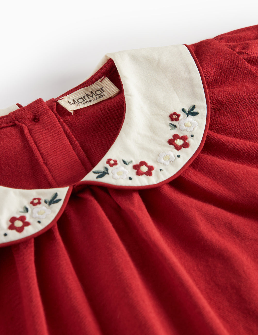 Rød julebluse med hvid krave og små blomsterbroderier til børn