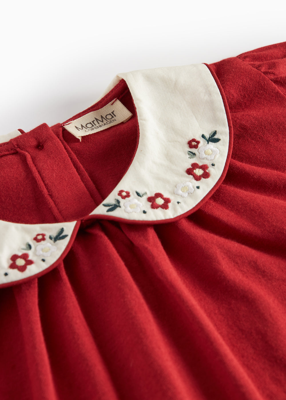 Rød julebluse med hvid krave og små blomsterbroderier til børn