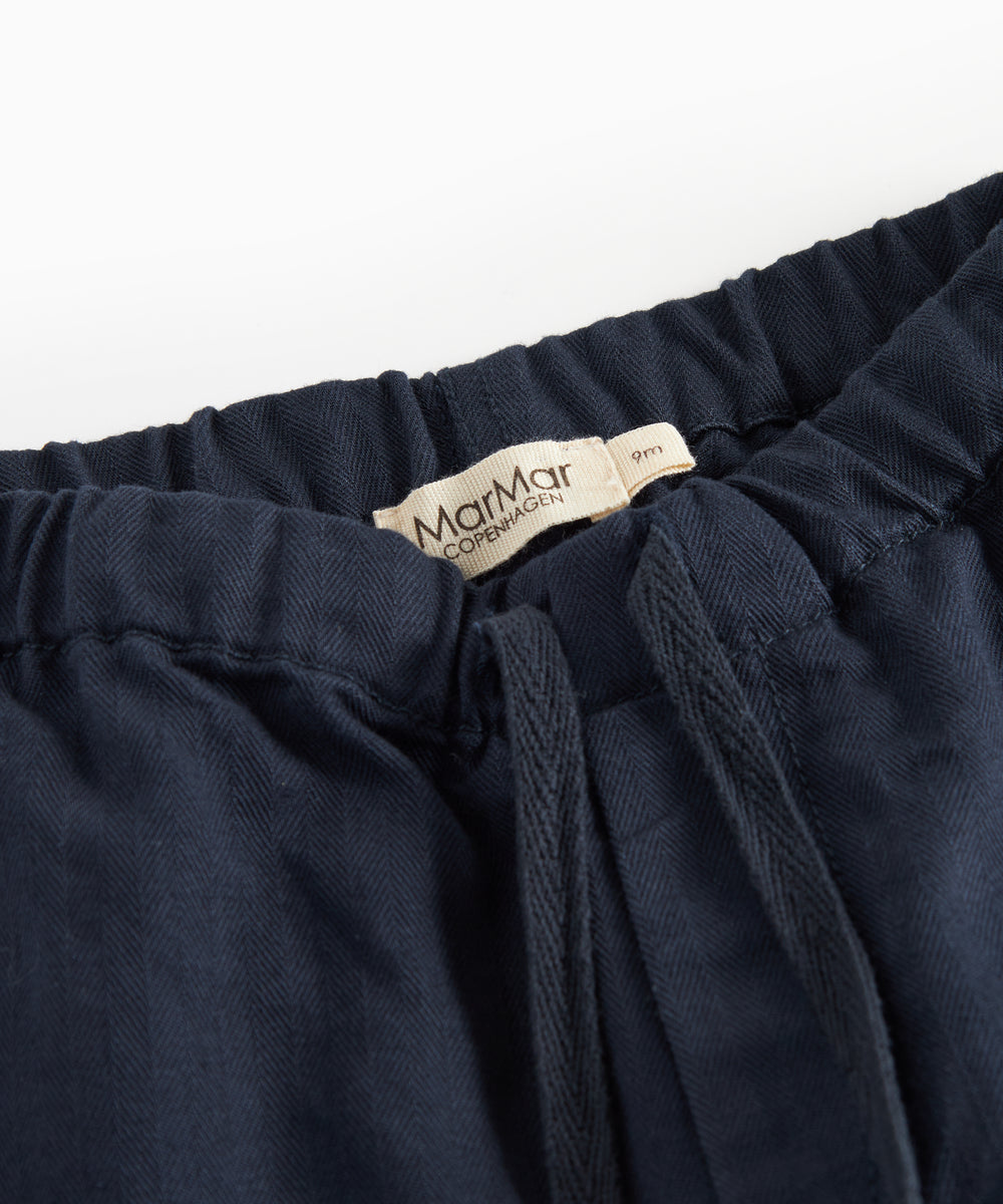 Mørkeblå bukser med elastisk talje og bindebånd i blødt stof til baby
