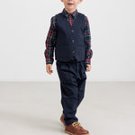 Dreng iført mørkeblå bukser og ternet skjorte i julelook til børn