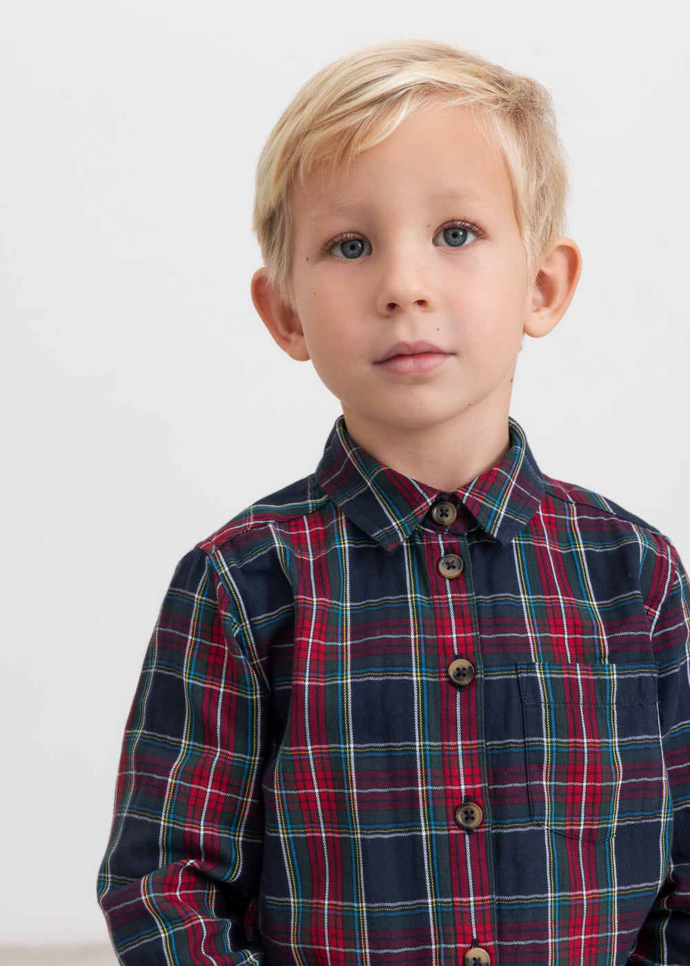 Dreng iført mørkeblå og rød ternet juleskjorte med knapper til børn
