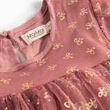 Nærbillede af overdel på rosa festkjole til børn i tyl med små gyldne mønstre