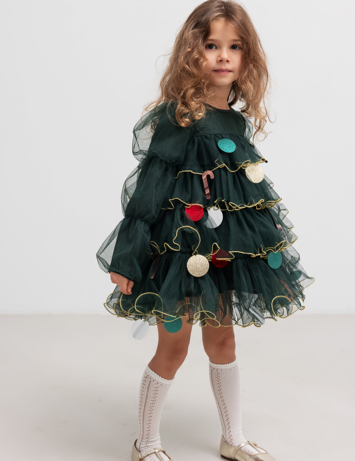 Barn i mørkegrøn tylkjole pyntet som et juletræ