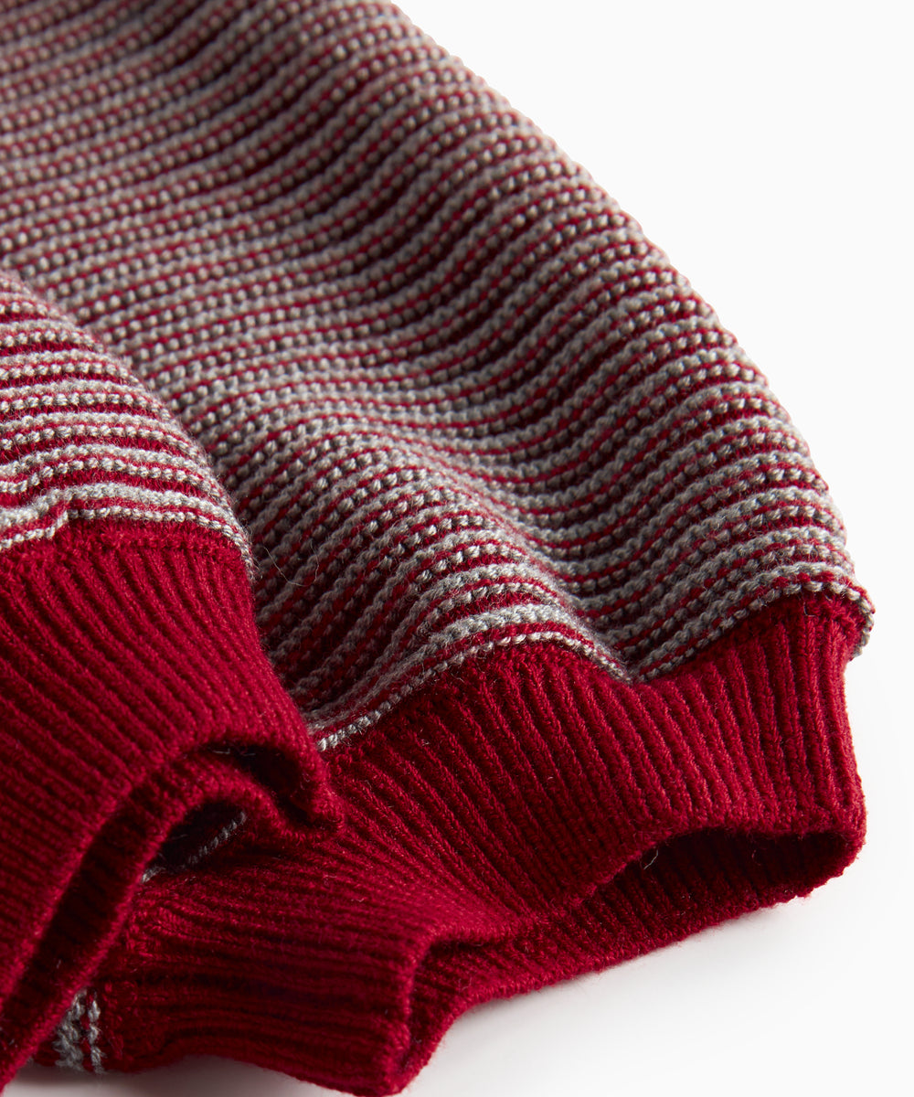 Strikkede bukser med røde og grå striber og seler til baby