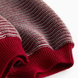 Strikkede bukser med røde og grå striber og seler til baby