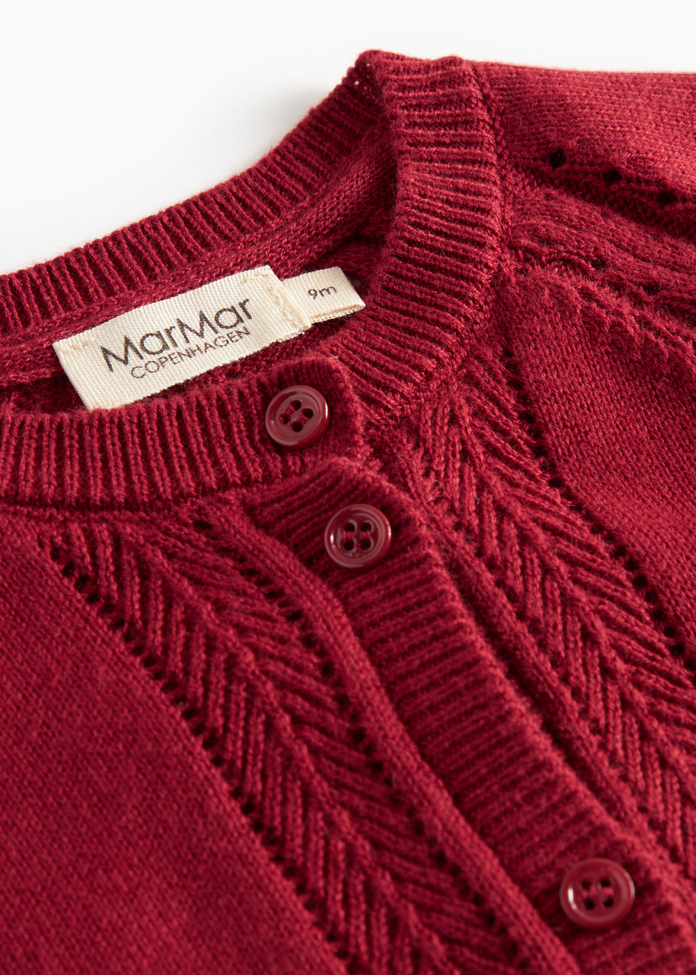 Rød cardigan med fine hulmønstre og ribkanter til baby