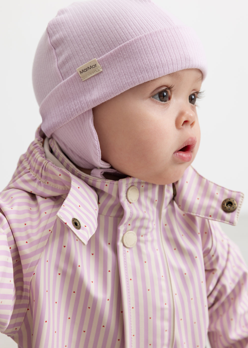 aby iført lyserød stribet regndragt med hætte og matchende hue