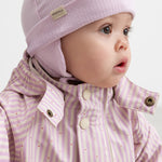 aby iført lyserød stribet regndragt med hætte og matchende hue