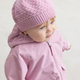Baby i lyserød overgangsjakke og lyserød strikket hue