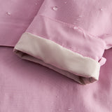 Detalje af lyserød overgangsjakke med vandperler på stof