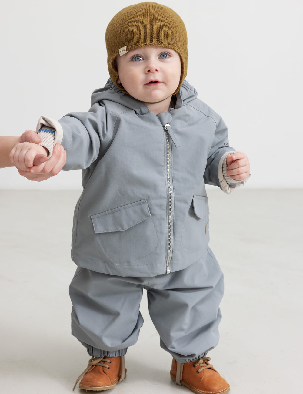 Barn iført grå overtræksbukser og matchende jakke